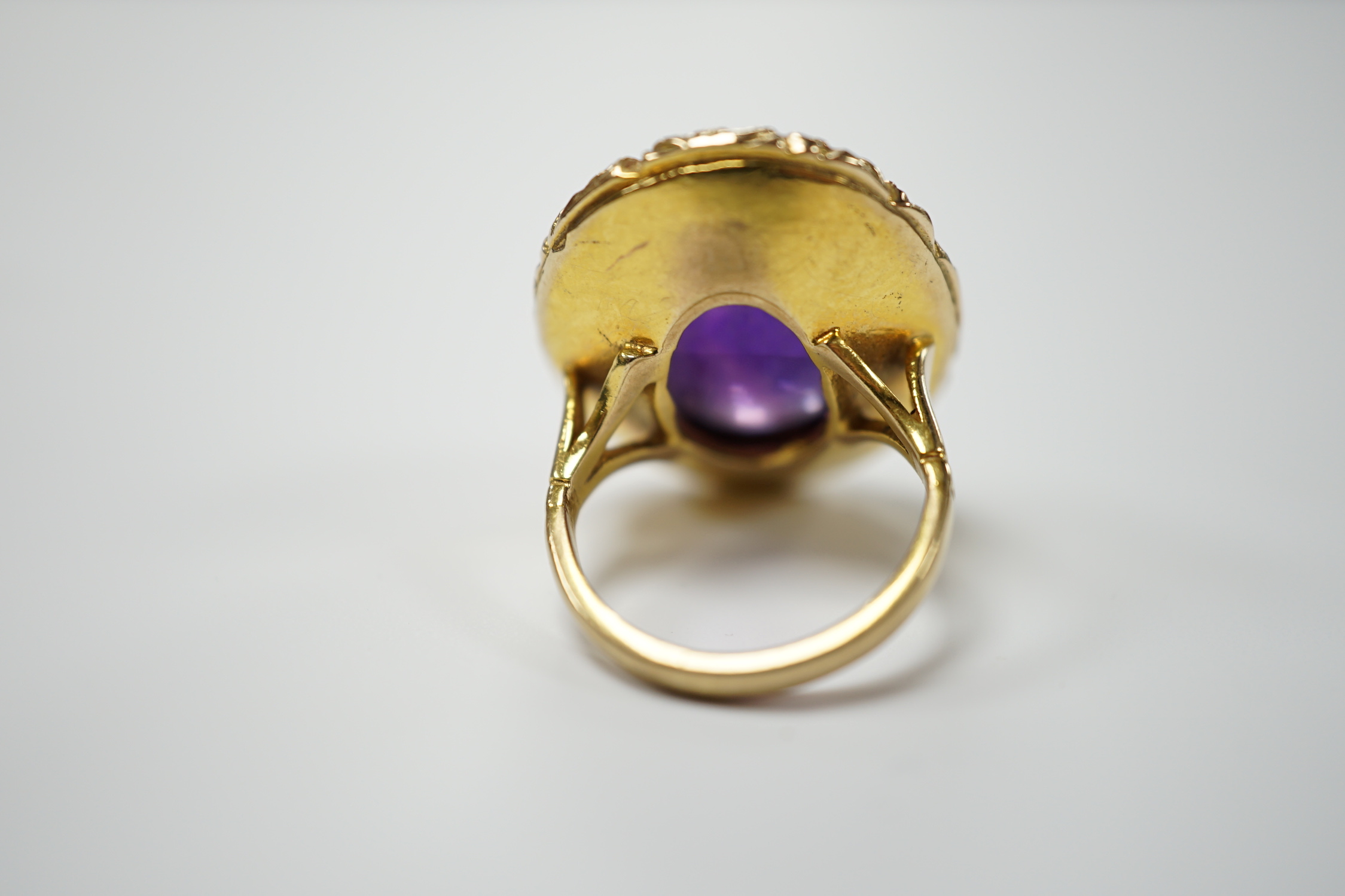 A 1970's Victorian style 9ct gold and cabochon amethyst set oval dress ring, size J, gross weight 13.1 grams.